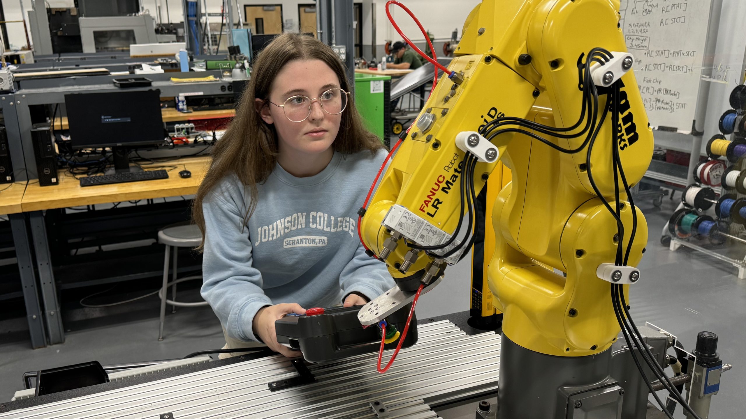student working with a robot arm